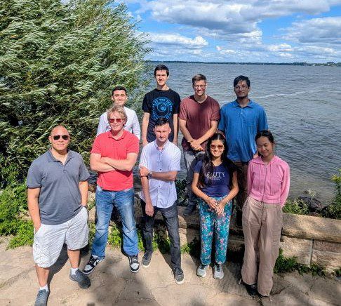 College age young adults posing for a picture after hiking to Picnic Point on Lake Mendota in Madison WI.