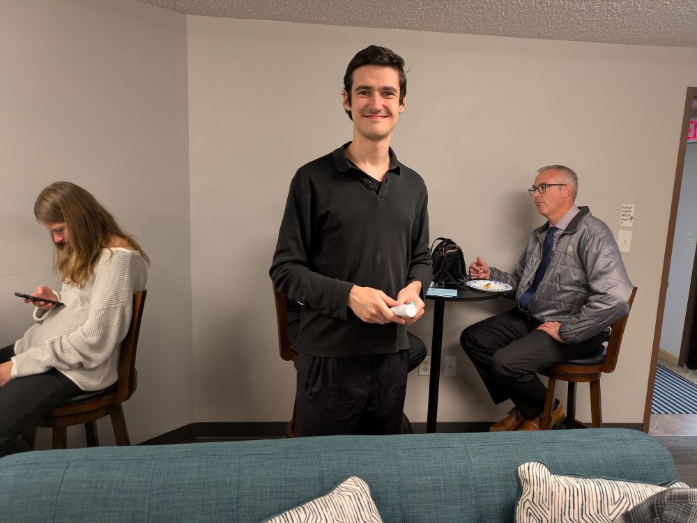 Slava after lunch - looks happy College age young adults playing a card game in a community space on campus.